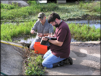 Patrick and his student record the measurements of the shells found in the ditch